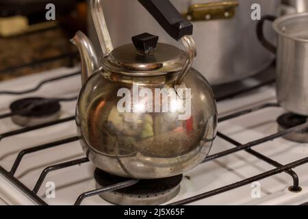 photographie de l'ancienne bouilloire métallique sur cuisinière à gaz Banque D'Images