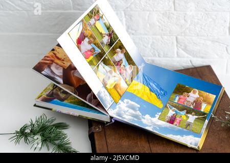 Archives photos de famille enregistrées dans un livre photo aux couleurs vives ; souvenirs d'été éclatants placés dans le livre photo. Famille avec drapeau de l'ukraine Banque D'Images
