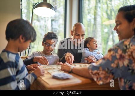 Famille jouant au scrabble à la table à manger Banque D'Images