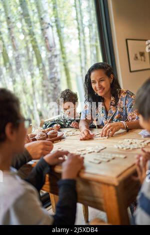 Bonne famille jouant au scrabble à la table à manger Banque D'Images