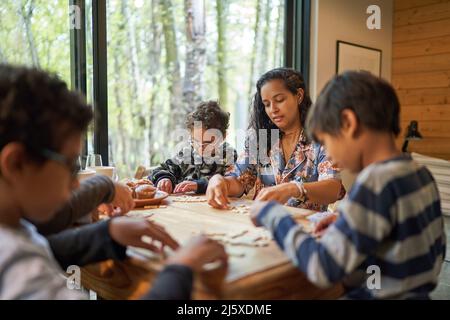 Famille jouant au scrabble à la table de cabine Banque D'Images