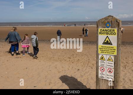 Talacre Beach-Flintshire, pays de Galles du Nord 18 avril 2022 vacanciers appréciant le soleil de printemps se dirigeant vers la mer par la plage de Talacre Banque D'Images