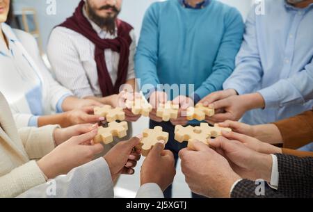 Une équipe diversifiée de gens d'affaires se joignant à des pièces de puzzle comme métaphore du travail d'équipe Banque D'Images