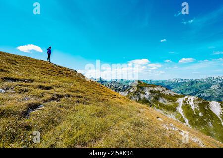 Belle femme est en randonnée au lac Schrecksee thourgh montagne pré dans les alpes bavaroises Banque D'Images