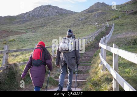 Couple avec des sacs à dos monter les escaliers sur la falaise Banque D'Images