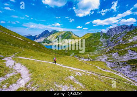 Woman marche le long d'un sentier de randonnée au lac Schrecksee dans les alpes bavaroises Banque D'Images