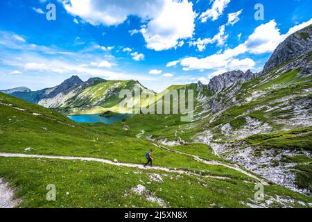 Woman marche le long d'un sentier de randonnée au lac Schrecksee dans les alpes bavaroises Banque D'Images