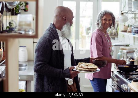 Joyeux couple senior qui cuisine dans la cuisine Banque D'Images