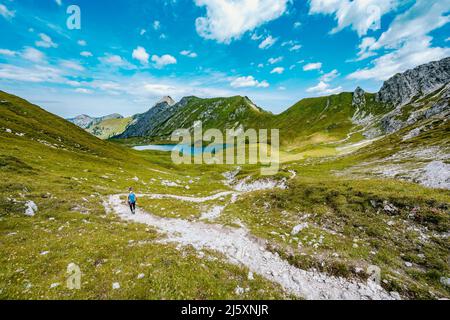 Woman marche le long d'un sentier de randonnée au lac Schrecksee dans les alpes bavaroises Banque D'Images