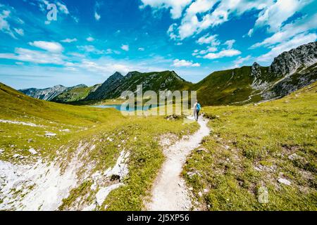 Woman marche le long d'un sentier de randonnée au lac Schrecksee dans les alpes bavaroises Banque D'Images