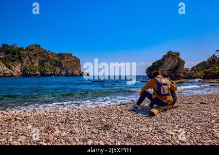un jeune couple admirant la mer, vu de l'arrière. Banque D'Images