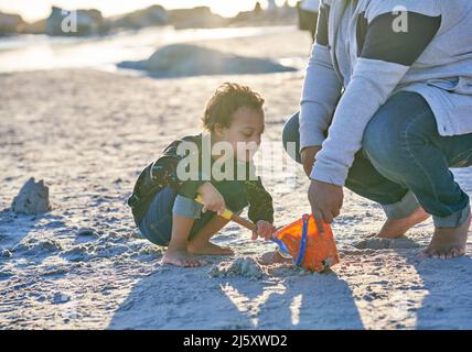 Père et fils avec le syndrome de Down jouant dans le sable sur la plage Banque D'Images