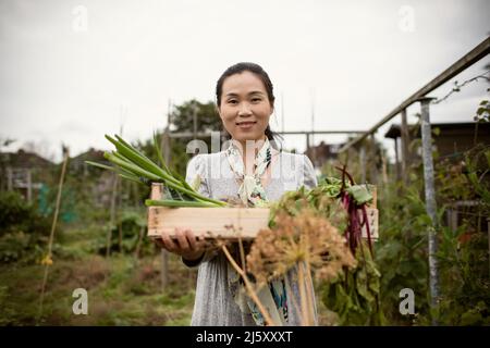 Portrait femme souriante avec légumes récoltés dans le jardin Banque D'Images