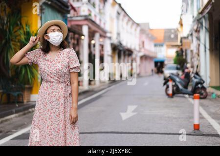 Les voyageurs avec masque marchant dans la rue de la vieille ville de Phuket avec bâtiment de l'architecture sino-portugaise dans la région de la vieille ville de Phuket, Thaïlande. Conc. Voyage Banque D'Images