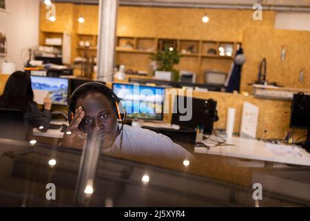 Homme d'affaires avec la tête dans les mains travaillant dans le bureau Banque D'Images