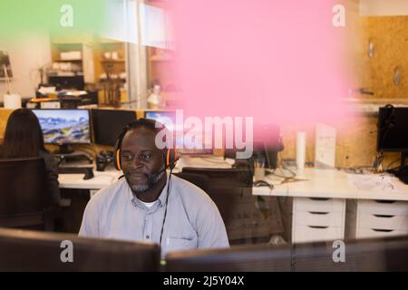 Homme d'affaires avec micro-casque travaillant au bureau Banque D'Images