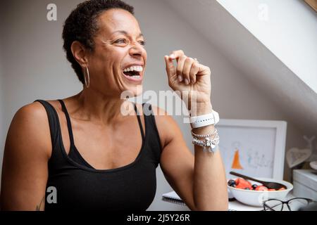 Bonne femme mûre riant et regardant loin Banque D'Images