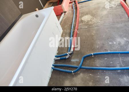 Pose de la ligne d'eau sur la baignoire pendant une rénovation de salle de bains dans une maison unifamiliale Banque D'Images