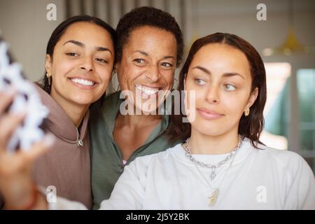 Bonne mère et jeunes filles adultes prenant le selfie Banque D'Images