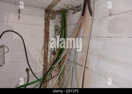 Beaucoup de câbles pendent du plafond pour l'installation électrique dans la salle du sous-sol Banque D'Images