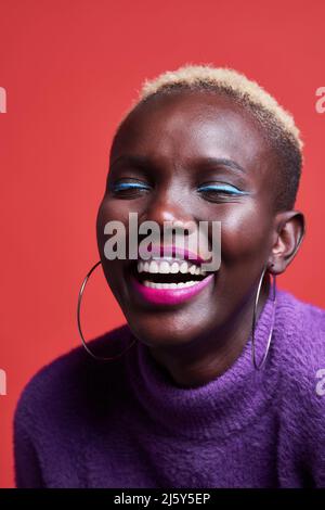 Gros plan d'une femme africaine souriante avec ses yeux fermés dans le studio Banque D'Images