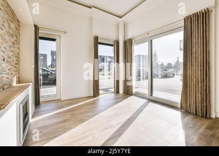 Intérieur d'un salon vide spacieux avec cheminée en plat avec plancher stratifié Banque D'Images