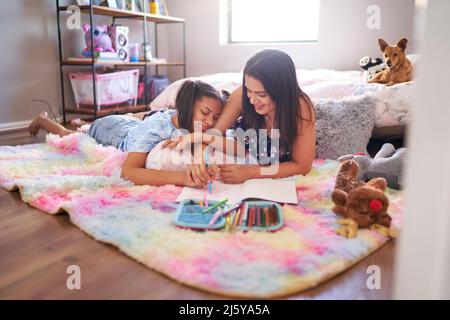 Mère et fille dessin sur le tapis de la chambre Banque D'Images