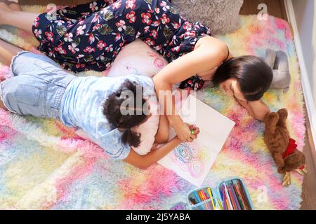 Vue du dessus des cercles de dessin de la mère et de la fille dans le bloc-notes Banque D'Images