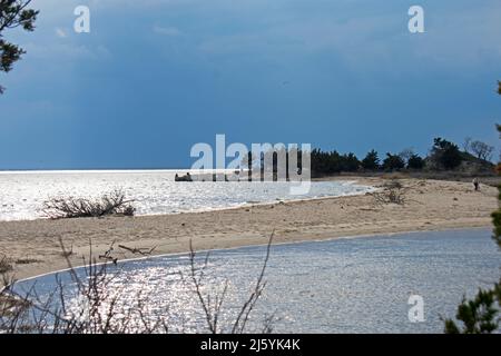 Une tempête printanière qui s'approche assombrit le ciel à Sandy Hook Bay alors que les rayons du soleil couchant se reflètent sur l'eau -19 Banque D'Images