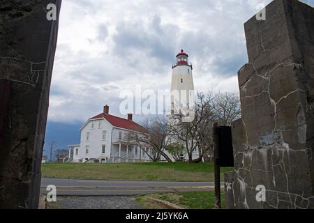 Phare de Sandy Hook, New Jersey, par une journée nuageux, vue d'une ouverture dans un grand mur de pierre -70 Banque D'Images