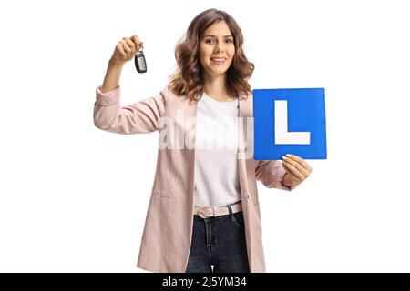 Jeune femme tenant des clés de voiture et une plaque d'apprentissage pour les conducteurs isolés sur fond blanc Banque D'Images