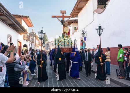 Les pénitents à capuchon catholiques romains portant des capirotes traditionnels portent une statue de Jésus-Christ lors de la procession du silence en célébration du Saint samedi, 16 avril 2022 à Patzcuaro, Michoacan, Mexique. La petite ville indigène conserve les traditions de la domination coloniale espagnole, y compris la confraternité des pénitents pendant la semaine sainte. Banque D'Images