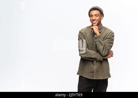 Portrait d'un jeune homme beau et heureux satisfait en chemise debout et regardant l'appareil photo avec un sourire crasseux. Studio d'intérieur tourné sur fond blanc Banque D'Images