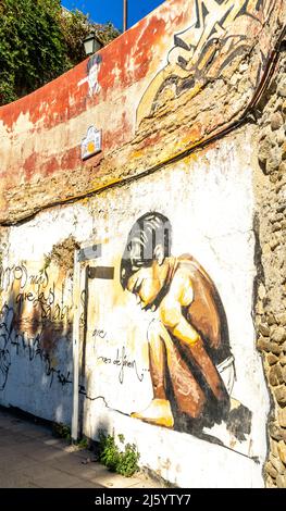 Garçon de squating, fresque d'art de rue de l'artiste Raul Ruiz. Enfant accroupi par le muraliste espagnol El Niño, Realejo, Grenade, Andalousie, Espagne Banque D'Images