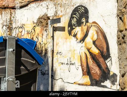 Garçon de squating, fresque d'art de rue de l'artiste Raul Ruiz. Enfant accroupi par le muraliste espagnol El Niño, Realejo, Grenade, Andalousie, Espagne Banque D'Images