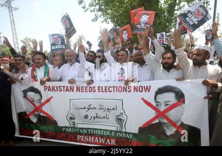 Hyderabad, Pakistan, 26 avril 2022. Les dirigeants et les activistes de Tehreek-e-Insaf (PTI) tiennent une manifestation pour réclamer des élections anticipées, en dehors du bureau de la commission électorale du Pakistan à Peshawar, le mardi 26 avril 2022. Banque D'Images