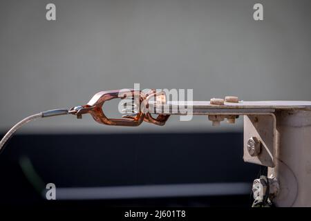 Borne de masse en cuivre fixée à une plaque métallique, adaptée à la décharge de courant et de tension dangereux dans un circuit électrique Banque D'Images