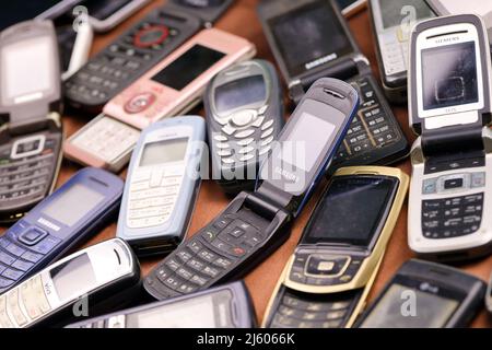 KHARKIV, UKRAINE - 16 DÉCEMBRE 2021 : certains vieux téléphones mobiles obsolètes utilisés de 90s-2000s période. Recyclage de l'électronique sur le marché bon marché Banque D'Images