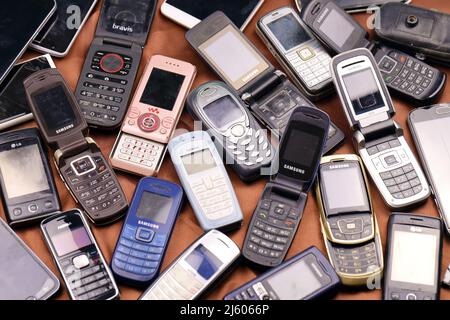 KHARKIV, UKRAINE - 16 DÉCEMBRE 2021 : certains vieux téléphones mobiles obsolètes utilisés de 90s-2000s période. Recyclage de l'électronique sur le marché bon marché Banque D'Images