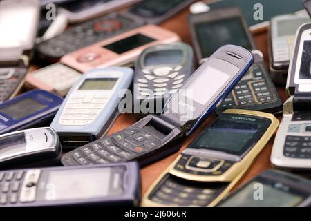 KHARKIV, UKRAINE - 16 DÉCEMBRE 2021 : certains vieux téléphones mobiles obsolètes utilisés de 90s-2000s période. Recyclage de l'électronique sur le marché bon marché Banque D'Images