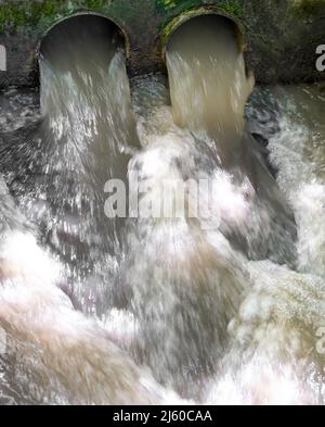 Plan d'évacuation d'eau au ralenti qui s'écoule à travers 2 ouvertures de tuyaux Banque D'Images