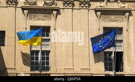 Le drapeau de l'Ukraine et le drapeau européen à la fenêtre agitant dans le vent. À l'appui de l'invasion de l'Ukraine et de son adhésion à l'Union européenne Banque D'Images