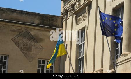 Le drapeau de l'Ukraine et le drapeau européen à la fenêtre agitant dans le vent. À l'appui de l'invasion de l'Ukraine et de son adhésion à l'Union européenne Banque D'Images