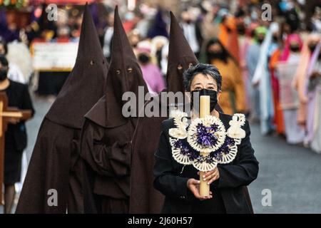 Les pénitents à capuchon catholiques romains portant des capirotes traditionnels tiennent une procession de silence le samedi Saint, 16 avril 2022 à Patzcuaro, Michoacan, Mexique. La petite ville indigène conserve les traditions de la domination coloniale espagnole, y compris la confraternité des pénitents pendant la semaine sainte. Banque D'Images