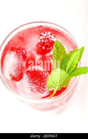 Cocktail de framboises.boisson d'été.boisson de framboise rose.cubes de glace avec framboises dans un verre avec eau, baies et feuilles de framboise . rafraîchissant Banque D'Images