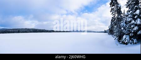 Vue panoramique d'un magnifique lac gelé et d'un ciel nuageux dans un parc national du Canada. Banque D'Images