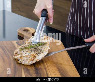 Le steak de porc cuit est placé sur une planche à découper en bois. Gros plan Banque D'Images