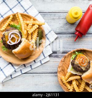 Vue de haut en bas des curseurs de cheeseburger servis avec des frites. Banque D'Images