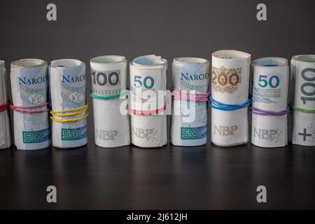 Billets roulés et attachés ensemble avec une bande en caoutchouc placée sur une table. Banque D'Images