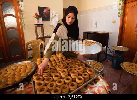 Gaza, Palestine. 26th avril 2022. Une femme palestinienne emboîte des bonbons traditionnels chez elle dans le centre de la bande de Gaza. Partout dans le monde, les musulmans se préparent à célébrer le bienheureux Eid Al-Fitr, qui coïncide avec la fin du mois Saint du Ramadan. Crédit : SOPA Images Limited/Alamy Live News Banque D'Images